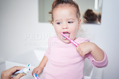 Buy stock photo Baby learning to brush her teeth, dental and oral hygiene. Toothbrush, toothpaste and brushing teeth in child development and routine. Dentist, dentistry and teeth cleaning in young children. 