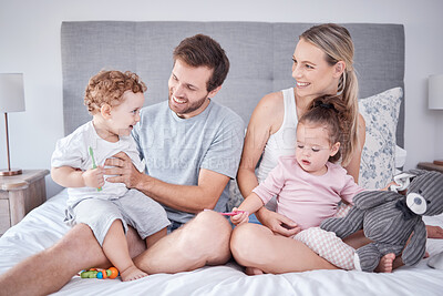 Buy stock photo Family, morning love and happiness with children and parents sitting on the bed and playing at home. Bond, playful and bedroom fun with a man and woman spending free time with their toddler kids