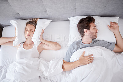 Buy stock photo Sleeping, snoring and wife with pillow on ears to stop noise from husband in bed with sleep problem. Insomnia, frustration and stress with tired woman in bedroom lying next to man with apnea