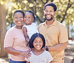 Portrait of a happy black family in nature in a garden for summer picnic while on holiday. Smile, love and african mother and father with their girl children in outdoor park on a countryside vacation