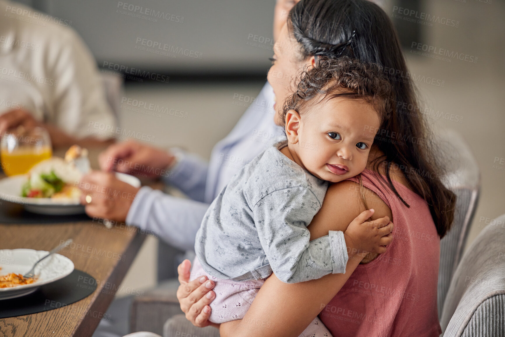 Buy stock photo Baby, mother and family while sitting at a dining tablet and eating food at a gathering, lunch or supper. Portrait of cute cild lying on shoulder of woman for love, comfort and happiness at home