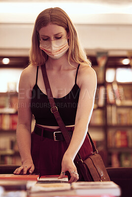Buy stock photo Covid, face mask and woman with books in a library, bookshop or educational building for knowledge, reading or research. Young female student browsing and choosing novel on table in a bookstore