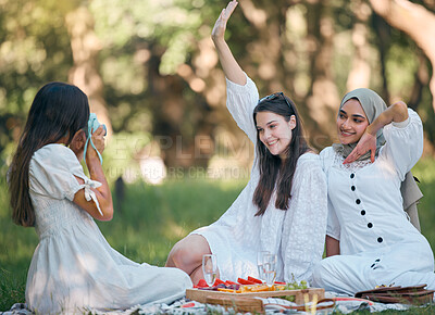 Buy stock photo Friends, camera and photo on a picnic in a forest with food and drinks on green grass. Diversity, fun and happy women enjoy bonding together in nature with snacks while posing for a photo or picture