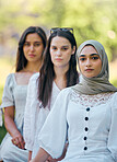 Muslim, islam and fashion with an islamic woman sitting outside with her friends in a line during the day. Religion, faith and belief with a an arab female outdoor in a row with her friendship group 