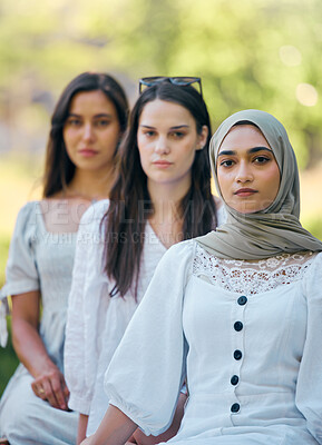 Buy stock photo Muslim, islam and fashion with an islamic woman sitting outside with her friends in a line during the day. Religion, faith and belief with a an arab female outdoor in a row with her friendship group 