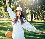 Happy woman in nature park dancing in summer with freedom, sunlight and natural fresh air in portrait. Dance, happiness and young girl with smile in casual dress having outdoor fun on spring holiday 