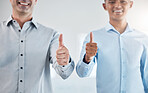 Thumbs up, thank you and motivation with a business man and colleague saying yes in studio on a gray background. Winner, goal and success with a male employee and coworker in agreement with a smile
