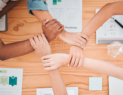 Buy stock photo Team building, diversity and top view of hands of business people in meeting for strategy, connection and support. Teamwork, mission and collaboration with employees holding wrist for community