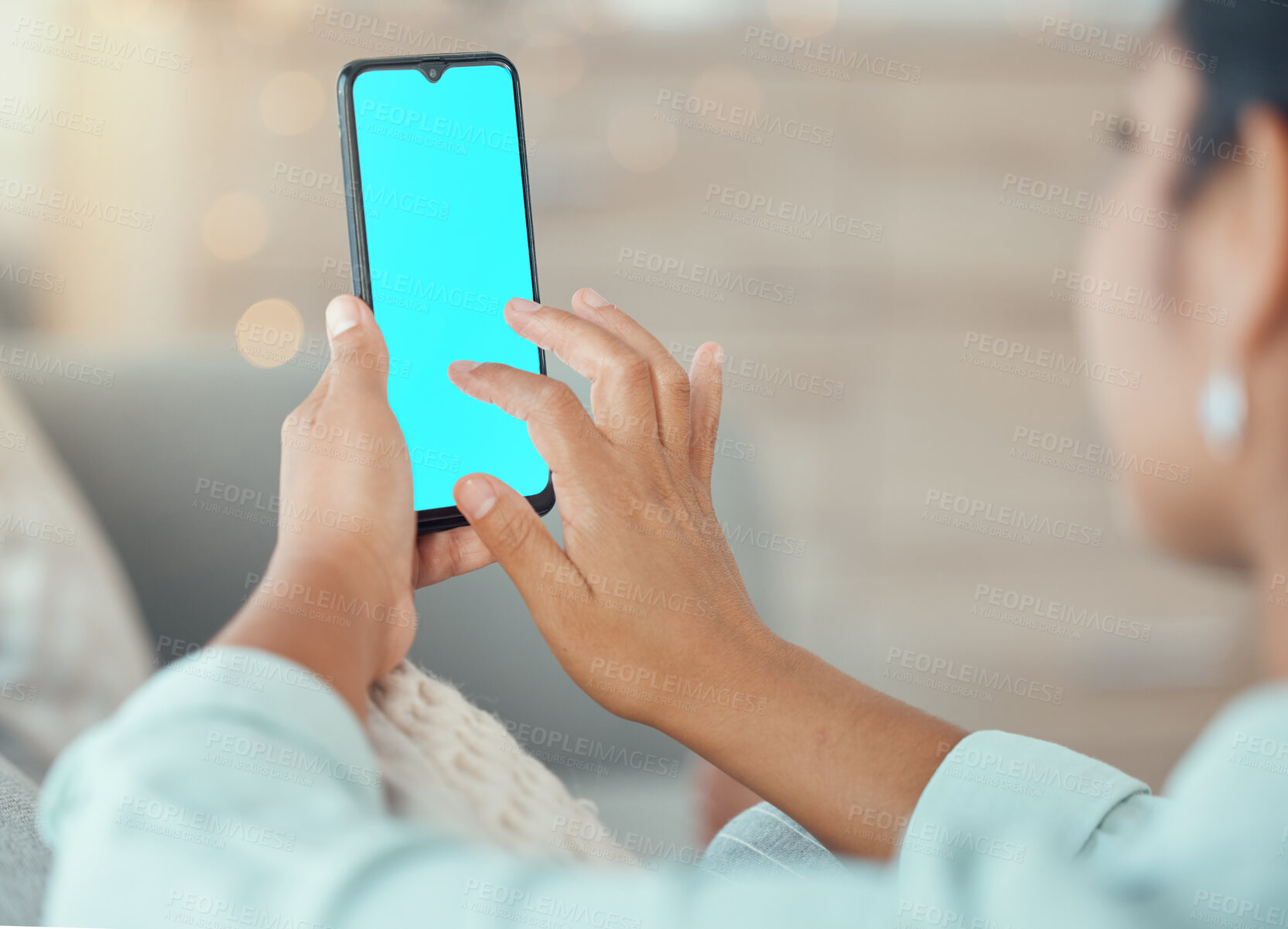 Buy stock photo Woman with green screen phone in hand, for mockup or marketing on living room sofa in home. Lady typing on smartphone with copy space for advertising for app developer or ecommerce company logo