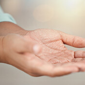 Person open hands for charity, support or poverty with lens flare and ...
