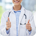 Healthcare, woman and thumbs up from doctor with a smile and blurred background. Success, thank you or approval from happy medical worker in hospital, cropped. Winner in medicine and yes to vaccine.