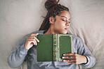 Tired, sleeping student with book on bed after studying, reading or learning knowledge at home. Burnout gen z or young black woman asleep in bedroom with textbook for university scholarship education