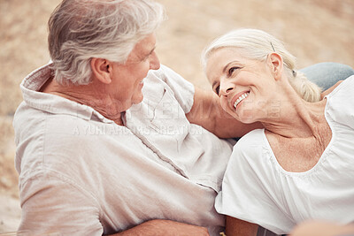 Buy stock photo Senior couple, beach and vacation with a smile, love and together while relax on the sand together in summer. Elderly man and woman enjoy romantic holiday, anniversary or date at the ocean in nature 