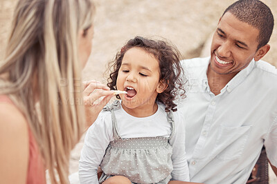 Buy stock photo Happy family picnic in nature mom feeding child and dad smiling. Man, woman and small girl spend time together outdoors on weekend. Young couple, relax and having snacks and fun with baby in nature.