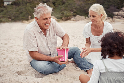 Buy stock photo Happy, sand and grandparents playing with their grandchildren at the beach during summer. Positive elderly man and woman building sandcastle with their grandkids by the ocean while on family vacation