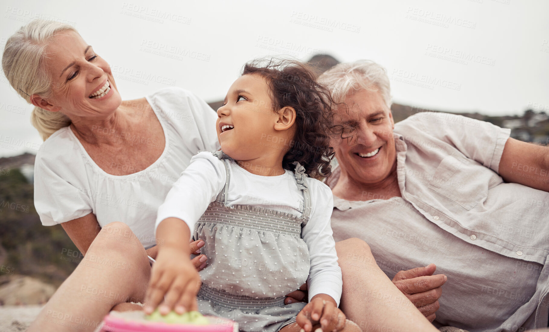 Buy stock photo Family, love and beach fun with kid and grandparents enjoying the sand, free time and bonding on summer holiday. Senior woman and man enjoying travel and playing with girl grandchild on a vacation