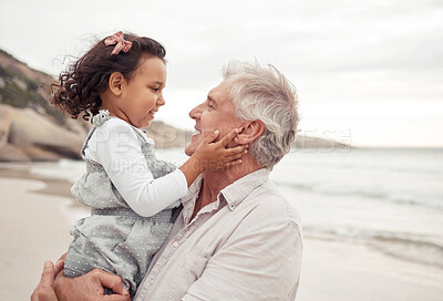 Buy stock photo Family, beach and bonding with grandfather and grandchild hug, sharing a sweet moment in nature together. Young girl holding senior man, having fun, talking and enjoying a day outdoors at the ocean