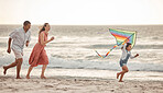 Happy family, beach vacation and child flying kite while running by the sea with her mother and father. Energy, fun and playing while bonding on holiday and summer travel with man, woman and kid