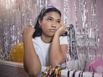 Girl in bath thinking during party with bored, tired or frustrated expression on face. Woman in bathroom, with crown and glitter from birthday celebration, feel sad, annoyed or disappointed in house