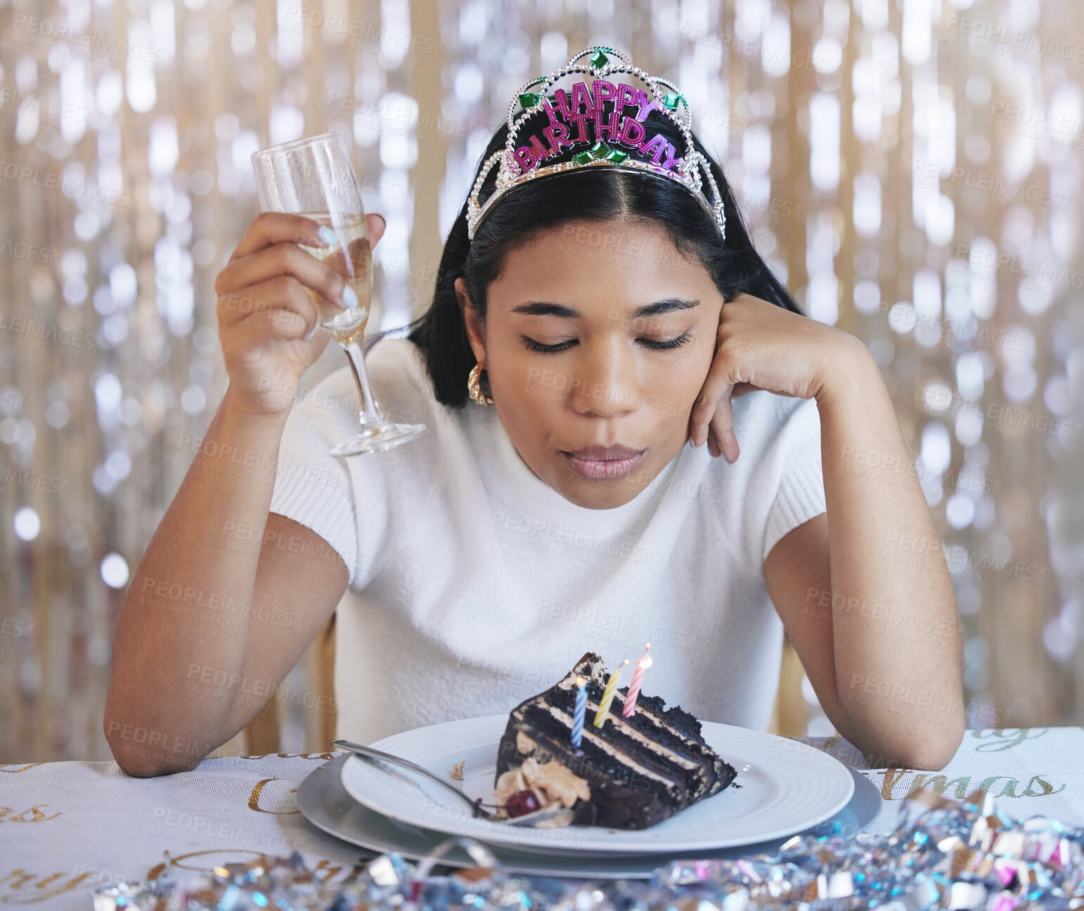 Buy stock photo Sad woman birthday cake, celebrate home alone with champagne and sad at lonely pandemic party celebration. Young latino girl fail to blow candle on table, wish thinking and shiny crown decoration