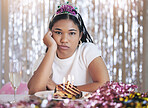 Bored, angry and birthday girl at a party at a celebration event with cake and candles upset. Portrait of a person from Mexico with sweet food feeling frustrated, sad and unhappy celebrating 