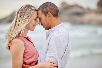 Buy stock photo Interracial couple, beach and love bond with forehead together in trust, security or safety. Smile, happy or latino man and woman in hug by ocean or sea water in nature environment for honeymoon date