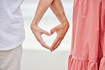 Couple hands, heart and love at beach outdoors for love, care and kindness emoji together. Closeup of happy people save the date relationship, finger shape and affectionate romance of trust marriage