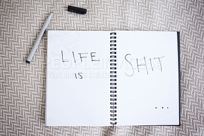 Buy stock photo Suicide, depression and a note with handwriting from suicidal thoughts. Mental health, sadness and a cry for help in notebook on a bed. Stress, anxiety and a sad message in writing that life is shit
