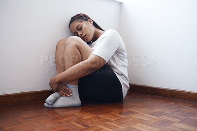 Buy stock photo Depression, anxiety and lonely woman sitting in a corner suffering from mental health issues or problems. Black female in stress, depressed or abuse alone on a wooden floor in apartment, home or room