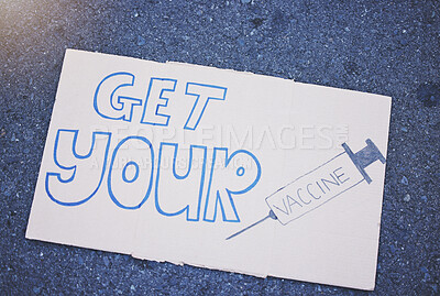 Buy stock photo Covid, vaccine and poster with a sign on the ground outside during the corona virus pandemic. Propaganda, motivation and advertising with writing on a board for vaccination, healthcare and medicine