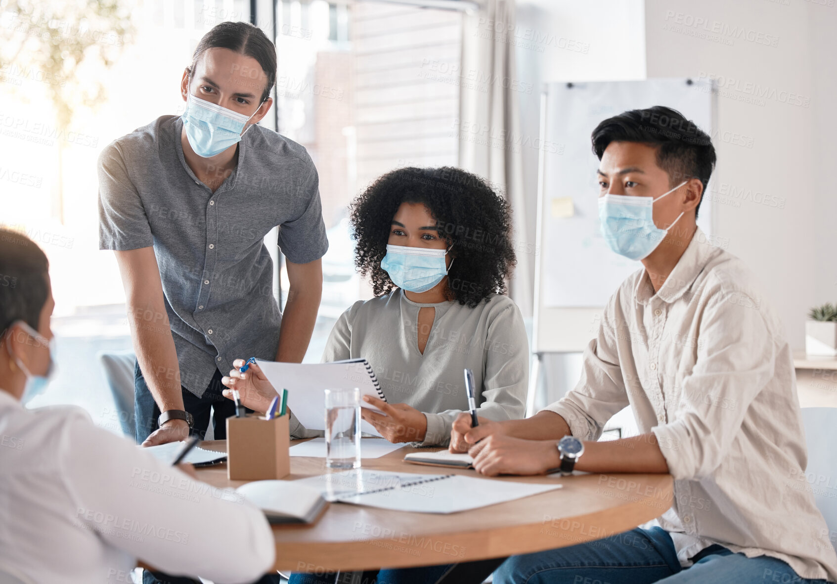 Buy stock photo Covid, business meeting and discussion with team listening to manager, mentor or boss while wearing face mask at boardroom table. Professional people sharing ideas, vision and mission strategy