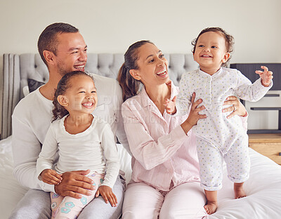 Buy stock photo Happy family, love and morning bonding with parents, child and baby playing in the bedroom and having fun together at home. Loving man and woman spending time with their playful kids to relax