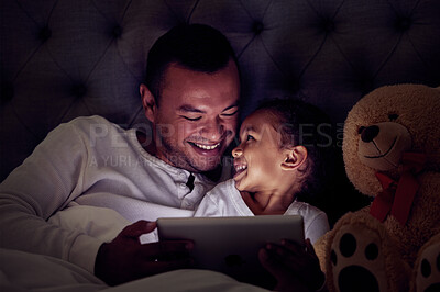 Buy stock photo Father and child in bed with tablet reading ebook or to watch a film together at night. Happy girl with her dad enjoying online live streaming movie, game or digital kid app in dark home bedroom