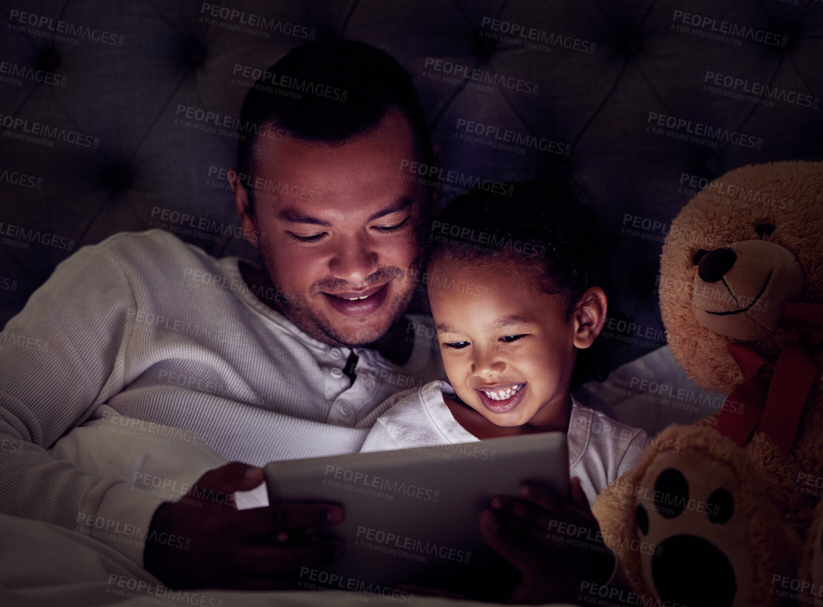 Buy stock photo Man, child and digital tablet streaming movies, cartoon or game in bed at night. Happy father and son browsing the internet, online or web with social media app while watching a comedy in the bedroom