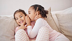 Girl, friends or children whisper secret to best friend on a home sofa while relax together on a play date. Communication, conversation and youth kids gossip at fun slumber party or sleepover event
