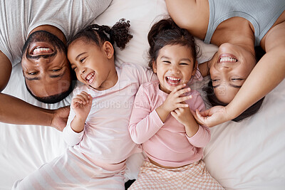 Buy stock photo Happy family, love and morning tickling with parents and children lying and playing in bedroom for fun together at home from above. Laughing and man and woman spending time with playful kids to bond
