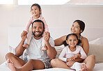 Family, children and love with a man and woman sitting on a bed with their kids at home. Happy, smile and girl with her sister, mother and father relaxing together in a bedroom in their house