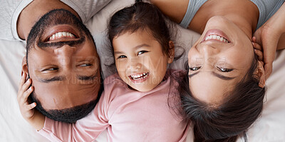 Buy stock photo Happy family with child on bed in a face portrait for interracial love, care and happiness together. Girl kid from Mexico with mother and father or parents relaxing at home and bonding  from above
