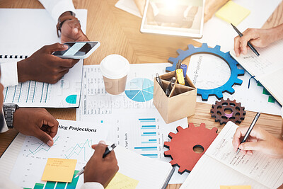 Buy stock photo Hands, teamwork and planning with a marketing team working on a table full of paperwork, gears and graphs. Collaboration, synergy and strategy with a business group at work in their modern office