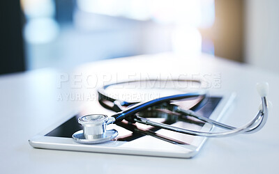 Buy stock photo Digital tablet, stethoscope and telehealth consulting on table in empty hospital, wellness and medicine insurance room. Zoom on medical equipment, healthcare research and internet technology for help