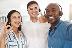 Woman, men and selfie of call center agents with headset, thumbs up and ok. Teamwork, support and help, a friendly, excited telemarketing or crm team. Customer service with smile on phone video call.