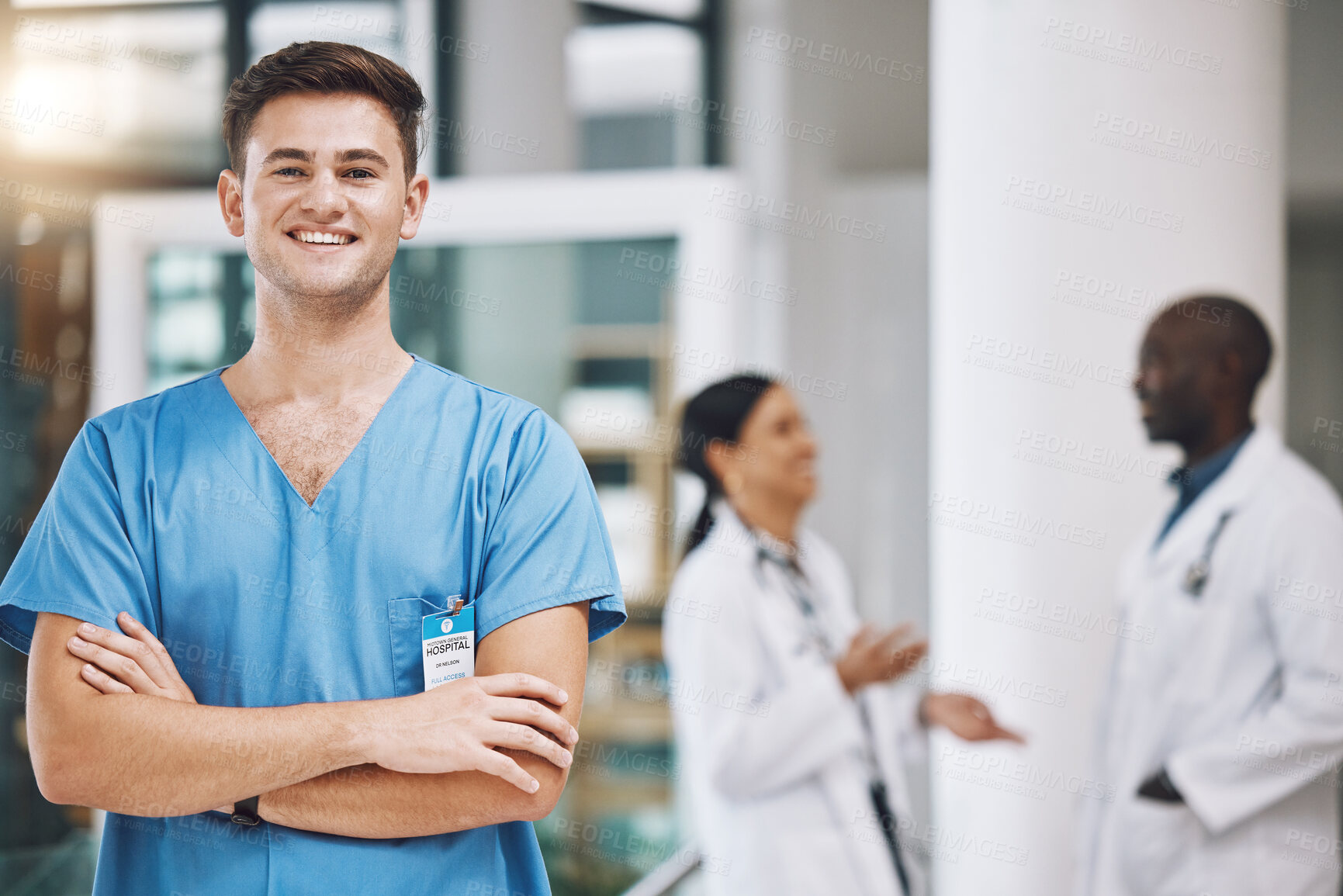 Buy stock photo Portrait of a male nurse with his team in the background in the hospital. Happy, smiling and confident nurse with doctors in medicine, health and medical care. Medical team, healthcare and nursing