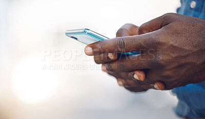 Buy stock photo Hands of an african man on a phone networking, doing research on the internet or typing a message. Closeup of a black guy browsing on social media, mobile app or an online website with a smartphone.