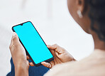 Woman on a phone with green screen networking on social media or reading online blog on website. Closeup of african hands holding smartphone while browsing on internet or mobile app while relaxing.