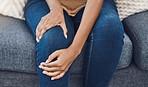 Black woman, hands and knee injury pain for person on house living room sofa or home interior lounge. Zoom on healthcare, wellness or medical surgery burnout, stress and legs muscle accident on couch