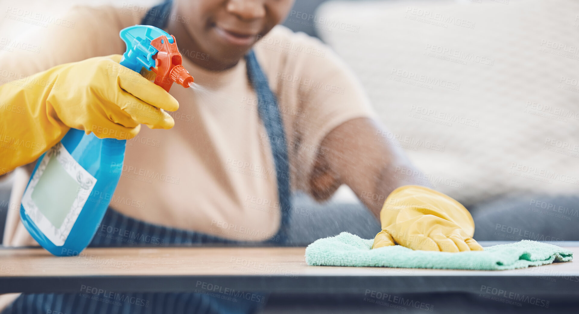 Buy stock photo Woman with detergent to clean, spray and wipe table, in office or living room in home. Black woman in domestic work, use cloth and liquid cleaner, on desk for hygiene in lounge of business or house