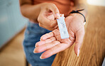 Woman hands holding a covid test for safety, healthcare and medicare with a negative result. Closeup of a rapid coronavirus antigen testing kit for a medical diagnosis exam with a pcr device at home.