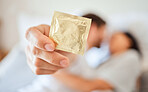Condom, safe and sexual intercourse couple using protection for hiv, sti and std health safety. Closeup hands of erotic man, love partner and sexuality birth control contraceptive in bedroom at home