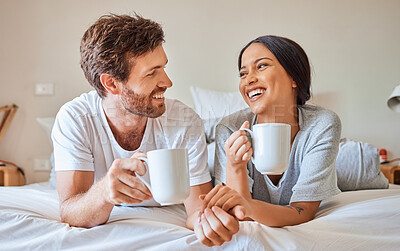 Buy stock photo Couple coffee, interracial smile and relax on bed in house, smile for love marriage and funny communication in bedroom of home. Man and woman happy with tea drink and comic conversation in morning
