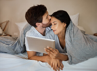 Buy stock photo Couple, love and tablet for entertainment while lying in bed with a kiss on forehead while watching a movie, internet browsing and streaming service. Loving man and woman in bedroom with 5g network